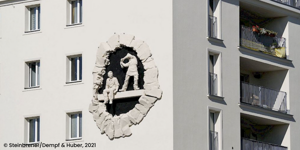 Urban renewal project: Georg Emmerling Hof. We see an artwork of construction workers on the side of the building.