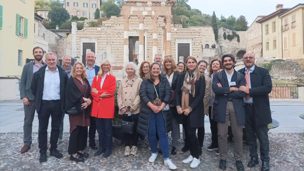 Network for social and public housing in Europe. Group photo in front of Roman ruins in Brescia.